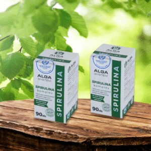 Alga System Spirulina Komplex 2x90 db-os, fehér, címkés flakonok, fa asztalon, zöld levelekkel a háttérben.