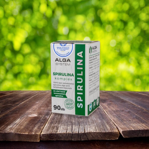 Alga System Spirulina Komplex kapszula 90 db – természetes magyar spirulina étrendkiegészítő doboza fából készült felületen, zöld természetes háttérrel